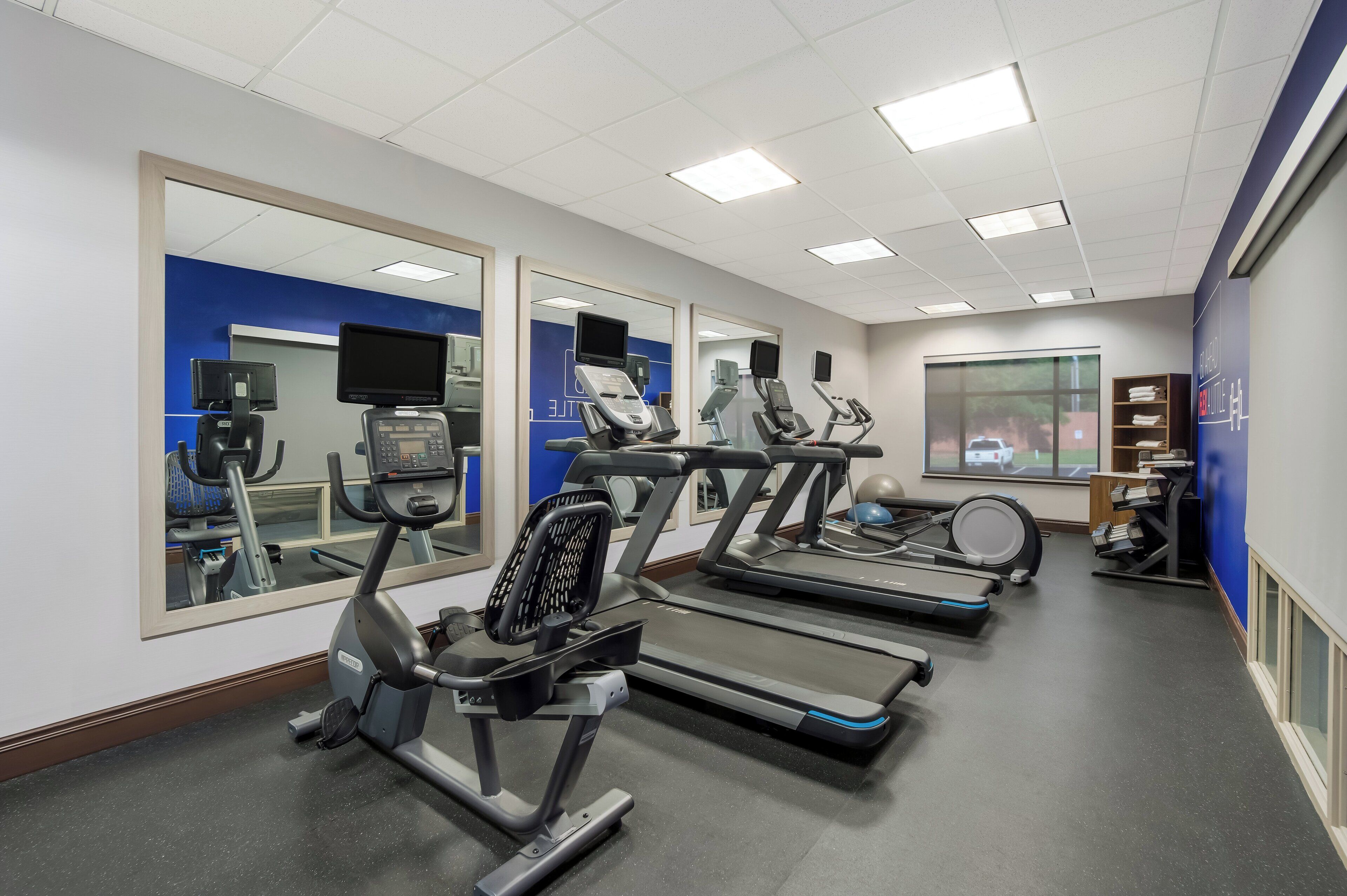 A gym with treadmills, an elliptical, and a stationary bike.