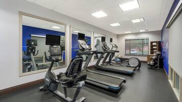 A gym with treadmills, an elliptical, and a stationary bike.