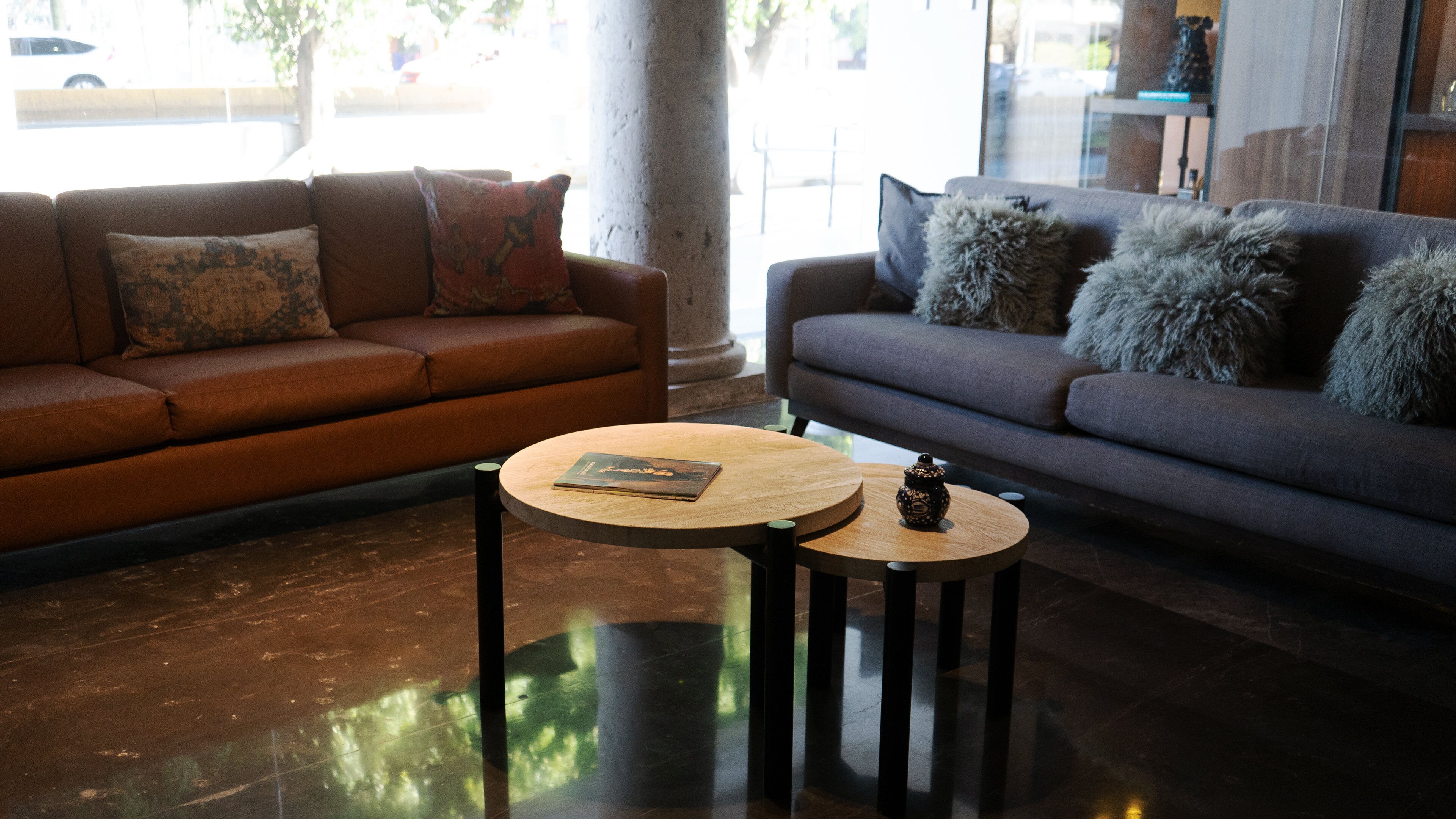 Una sala de estar moderna con dos sofás, una mesa de centro y un jarrón decorativo.