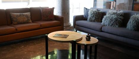 A modern living room with two sofas, a coffee table, and a decorative vase.
