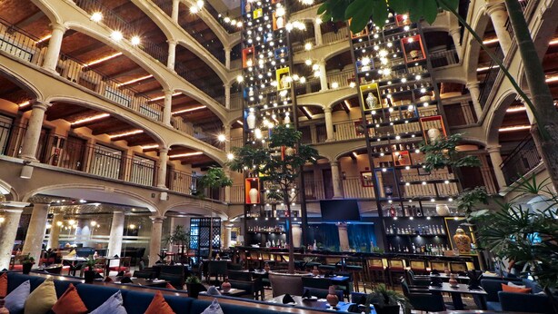 A multi-level atrium with a central column, seating areas, and a variety of lighting fixtures.