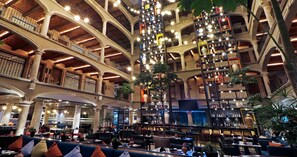 A multi-level atrium with a central column, seating areas, and a variety of lighting fixtures. - Hotel Indigo Guadalajara Expo by IHG (Guadalajara)