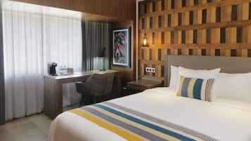 Une chambre d’hôtel avec un lit, un bureau, une chaise et un panneau mural en bois.