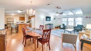 A spacious living room with a dining area, kitchen, and a large window providing natural light. - Pet-Friendly St Augustine Home w/ Dock & Yard! (St. Augustine)