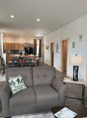 Relax in this stylish living room with a sofa, table, and lamp, surrounded by a clean and minimalist design.