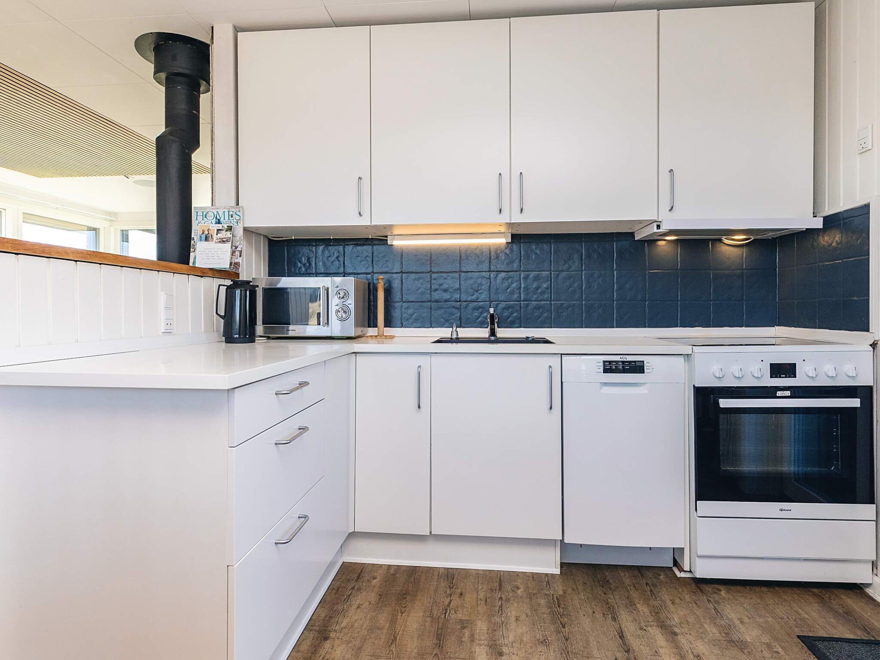 A modern kitchen with white cabinetry, a built-in microwave, a stove, and a dishwasher.