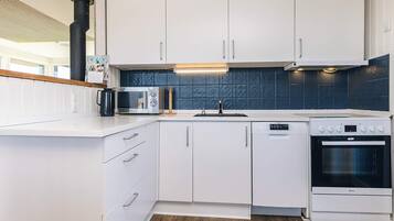 A modern kitchen with white cabinetry, a built-in microwave, a stove, and a dishwasher.