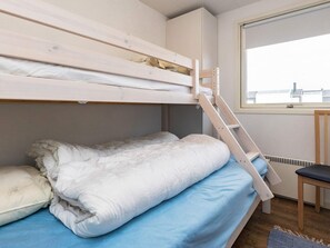 A bunk bed with a ladder, a single bed with a blue mattress, and a chair. - 4 Star Holiday Home in Hjorring (Hjørring)