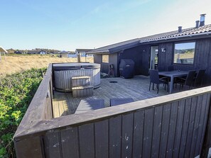 A wooden deck with a hot tub, grill, and outdoor seating area. - 4 Star Holiday Home in Hjorring (Hjørring)