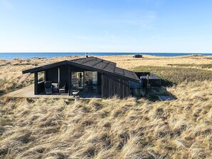 A modern beach house with a deck, large windows, and a view of the sea. - 4 Star Holiday Home in Hjorring (Hjørring)