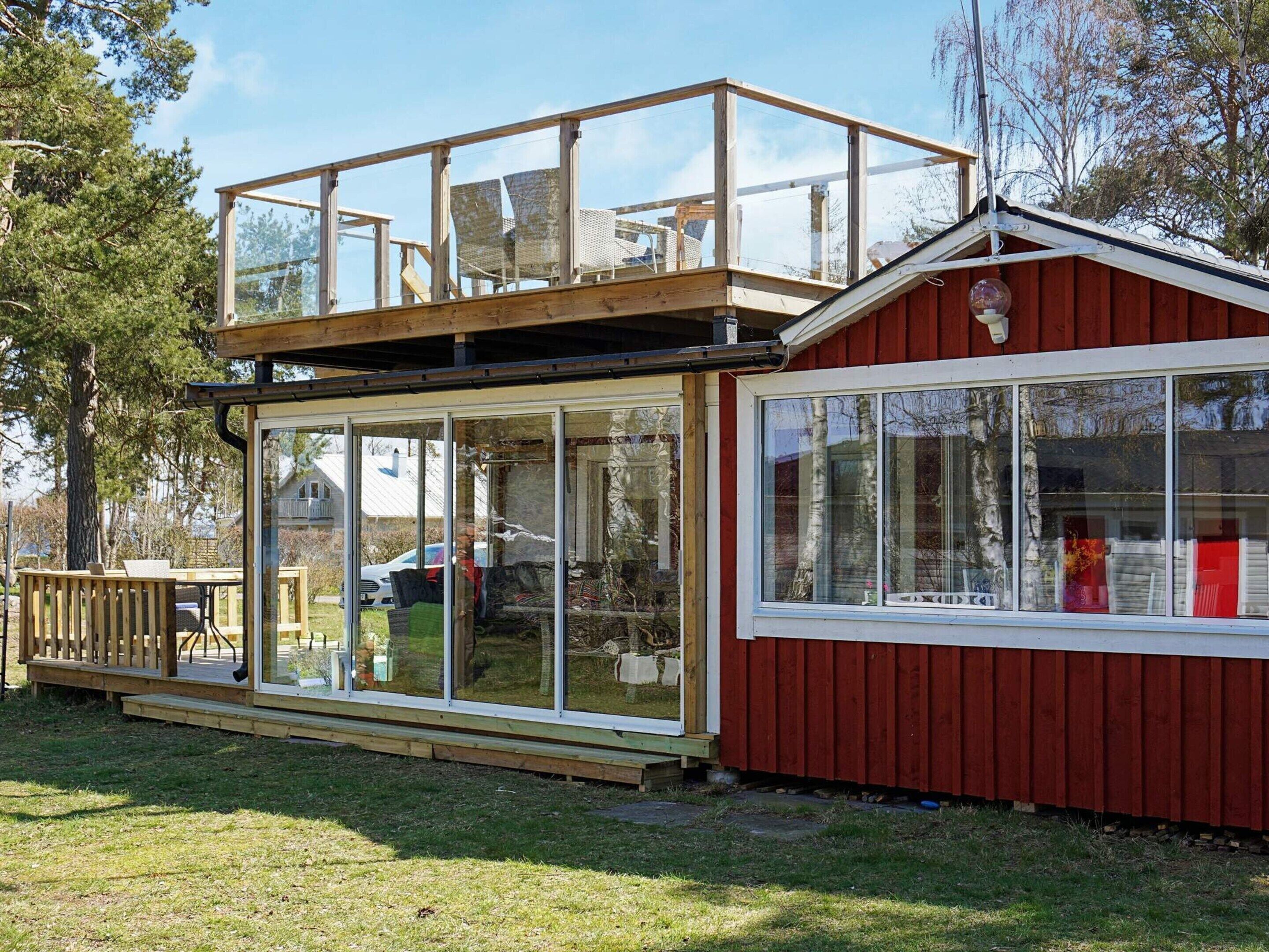 A two-story wooden structure with large glass windows and a red exterior.