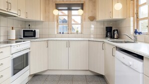 A kitchen with wooden cabinets, a microwave, a coffee maker, and a dishwasher.