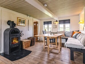Ein gemütliches Zimmer mit Kamin, Holzmöbeln und einem Esstisch.
