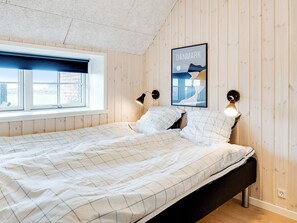 A bedroom with a bed, two bedside lamps, a window, and a wall-mounted picture of Denmark. - 5 Star Holiday Home in Ringkobing (Ringkobing)
