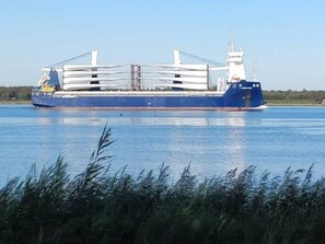 A large cargo ship with a white superstructure and multiple white masts on a calm body of water. - 8 Person Holiday Home in Storvorde (Storvorde)