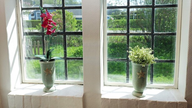 Two windows with a view of a garden and a fence. - 8 Person Holiday Home in Storvorde (Storvorde)