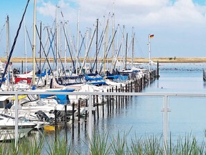 A marina with multiple boats docked at wooden piers.