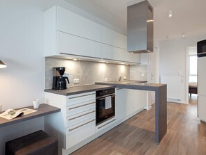 A modern kitchen with a built-in oven, a coffee maker, and a countertop.