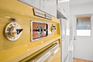Ein alter General Electric Elektroherd mit Drehreglern und einer Holzplatte.