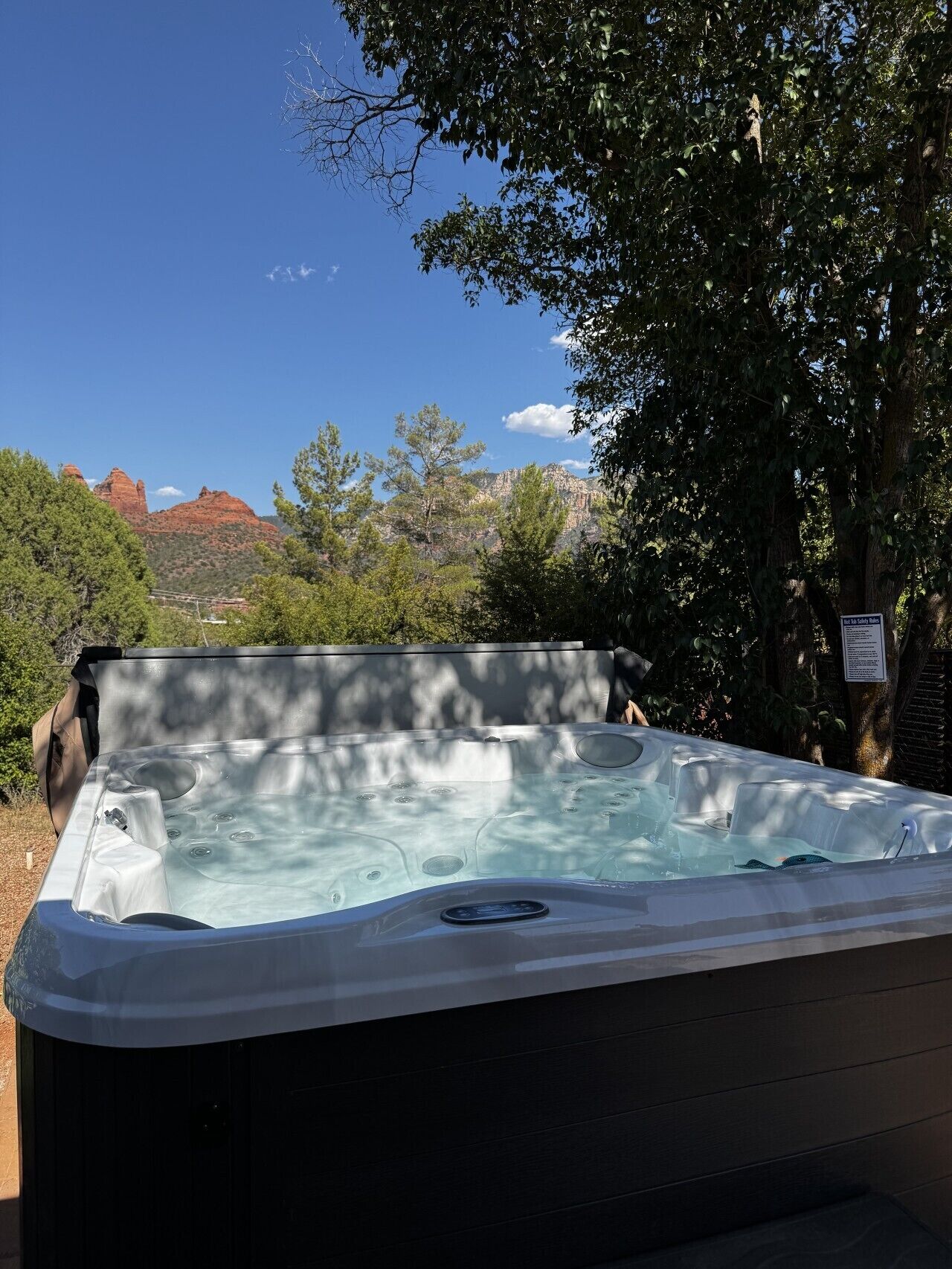 A hot tub with a clear view of red rock formations in the background.