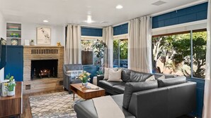 Una sala de estar con chimenea, un sofá, un sillón y una mesa de centro.
