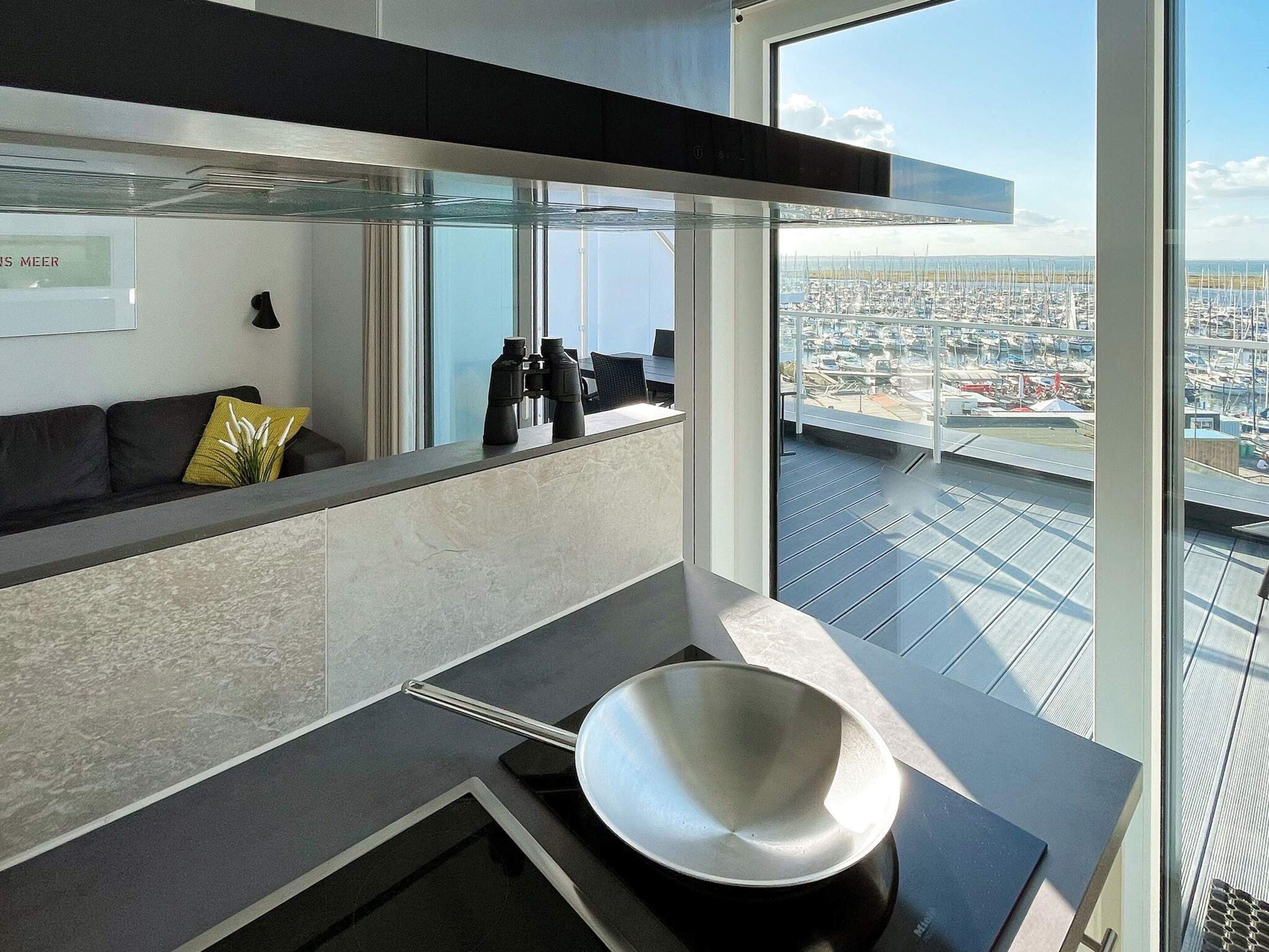 Una cucina moderna con un'ampia finestra che si affaccia su un porto turistico.