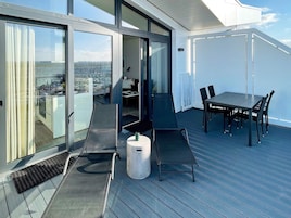 En moderne udendørs terrasse med et spisebord og en stol.