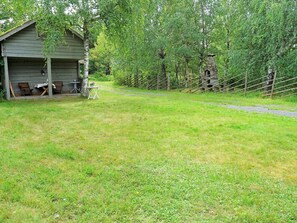 A rustic cabin with a porch, a small table, and chairs. - 5 Person Holiday Home in Tingsryd (Tingsryd)