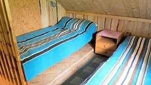 A cabin with two bunk beds, a wooden chest, and a small table. - 5 Person Holiday Home in Tingsryd (Tingsryd)