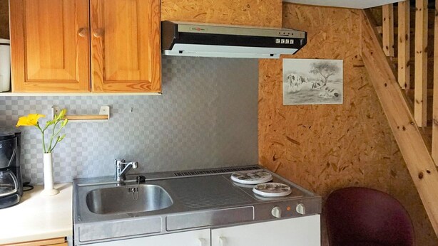 A compact kitchen with a sink, stove, and wooden cabinets. - 5 Person Holiday Home in Tingsryd (Tingsryd)