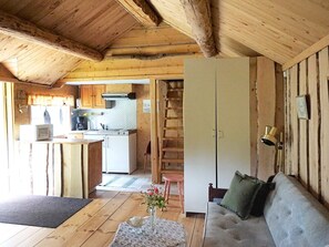Un intérieur en bois comprenant une cuisine, un coin repas et un salon avec un canapé.
