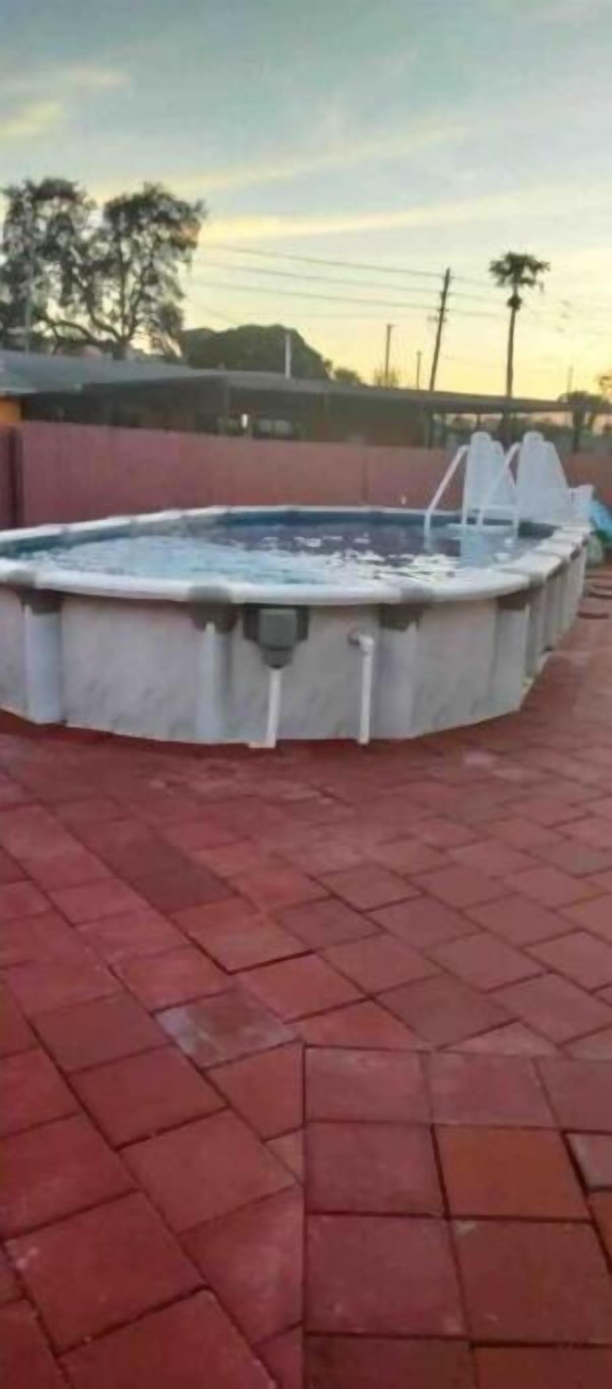 Une piscine avec une terrasse carrelée.
