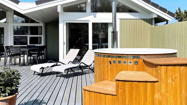 A modern house with a deck, outdoor seating, and a hot tub. - 8 Person Holiday Home in Dronningmolle (Dronningmolle)