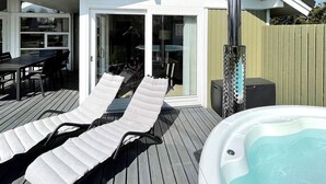 A poolside area with lounge chairs and a hot tub. - 8 Person Holiday Home in Dronningmolle (Dronningmolle)