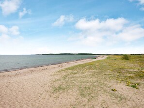 Ein Strand mit sandigem Ufer und einem kleinen Boot.