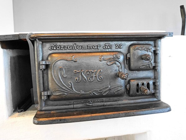 A vintage stove with ornate metalwork and inscriptions, likely a historical artifact.