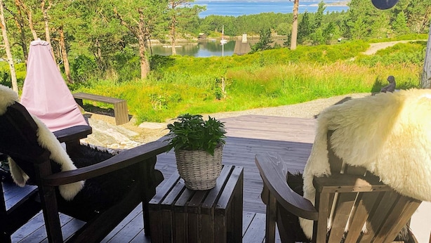 A wooden deck with two chairs, a small table, and a potted plant. - 4 Star Holiday Home in Aure (Aure)
