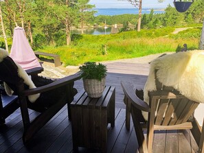 A wooden deck with two chairs, a small table, and a potted plant. - 4 Star Holiday Home in Aure (Aure)