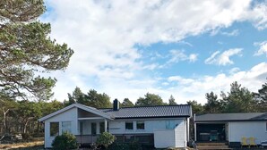 A two-story cabin with a porch, surrounded by trees and a clear sky. - 4 Star Holiday Home in Aure (Aure)