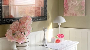 A white dresser with a vase of pink flowers, a small figurine, and a white lamp. - 4 Star Holiday Home in Aure (Aure)