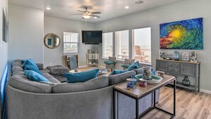 A modern living room with a sectional sofa, a coffee table, and a television.