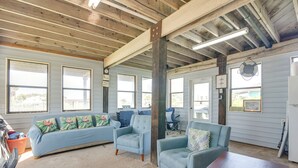 A spacious living area with a light blue sofa, two matching armchairs, a wooden coffee table, and a large window providing natural light. - Waterfront Texas Abode w/ Boat Ramp, Pets Welcome (Sargent)