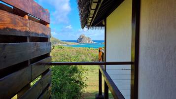 A balcony with a view of a rocky island and the ocean.