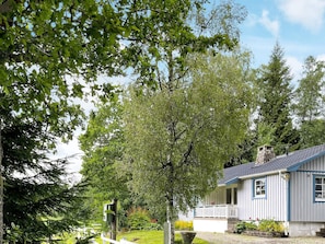 A house with a porch, surrounded by trees and a well-maintained lawn. - 6 Person Holiday Home in Trollhattan (Trollhattan)