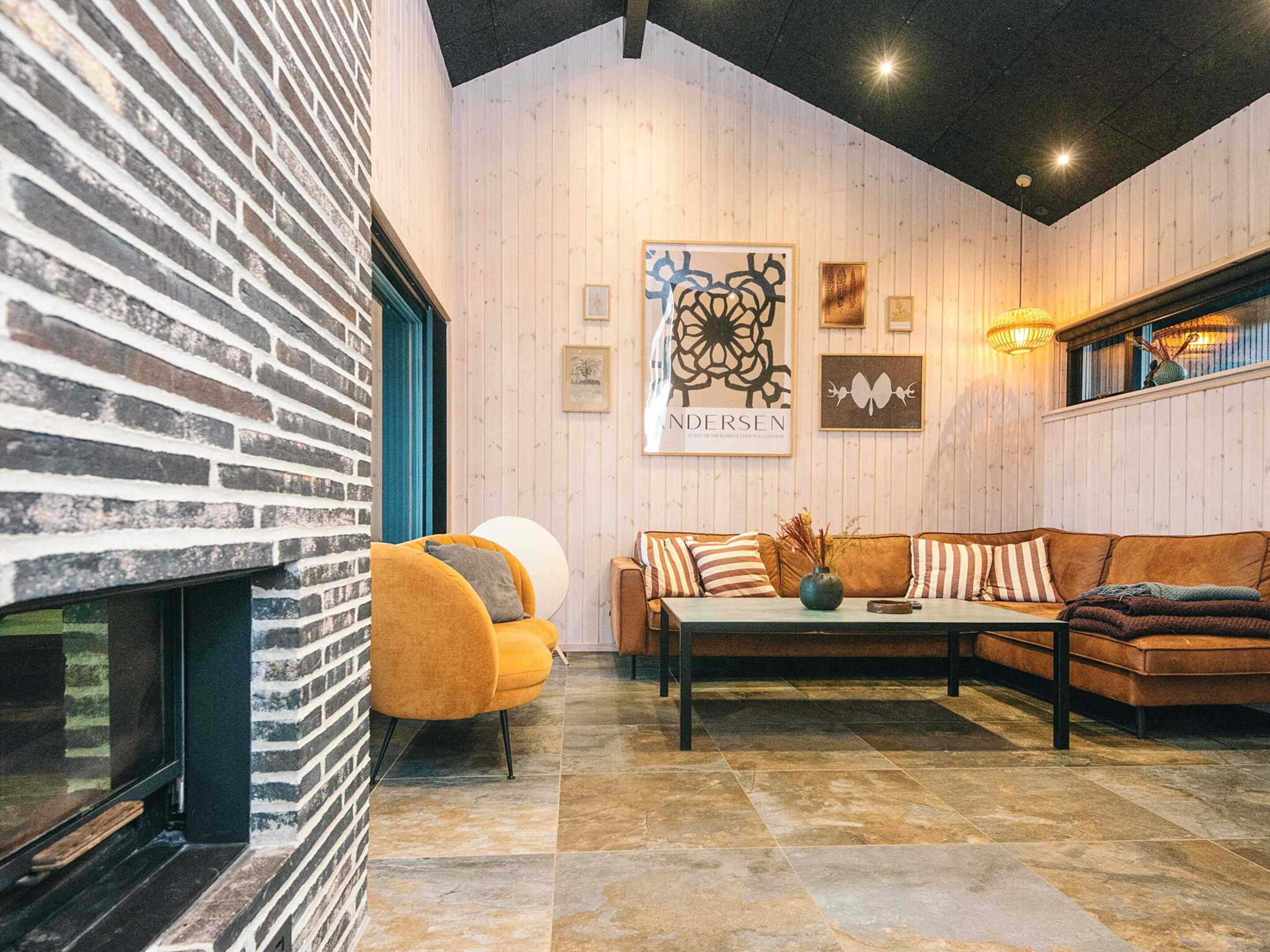 A cozy living room with a brick wall, a sofa, a coffee table, and a fireplace.