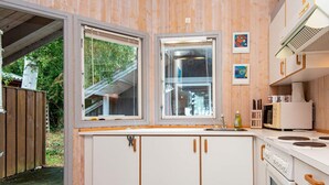 Une cuisine de taille réduite avec des meubles blancs, un four encastré et un four à micro-ondes.
