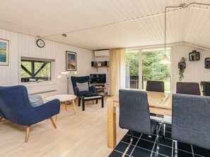 Un salon confortable avec un téléviseur, des sièges et un coin repas.
