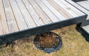 A wooden deck with a metal grill.