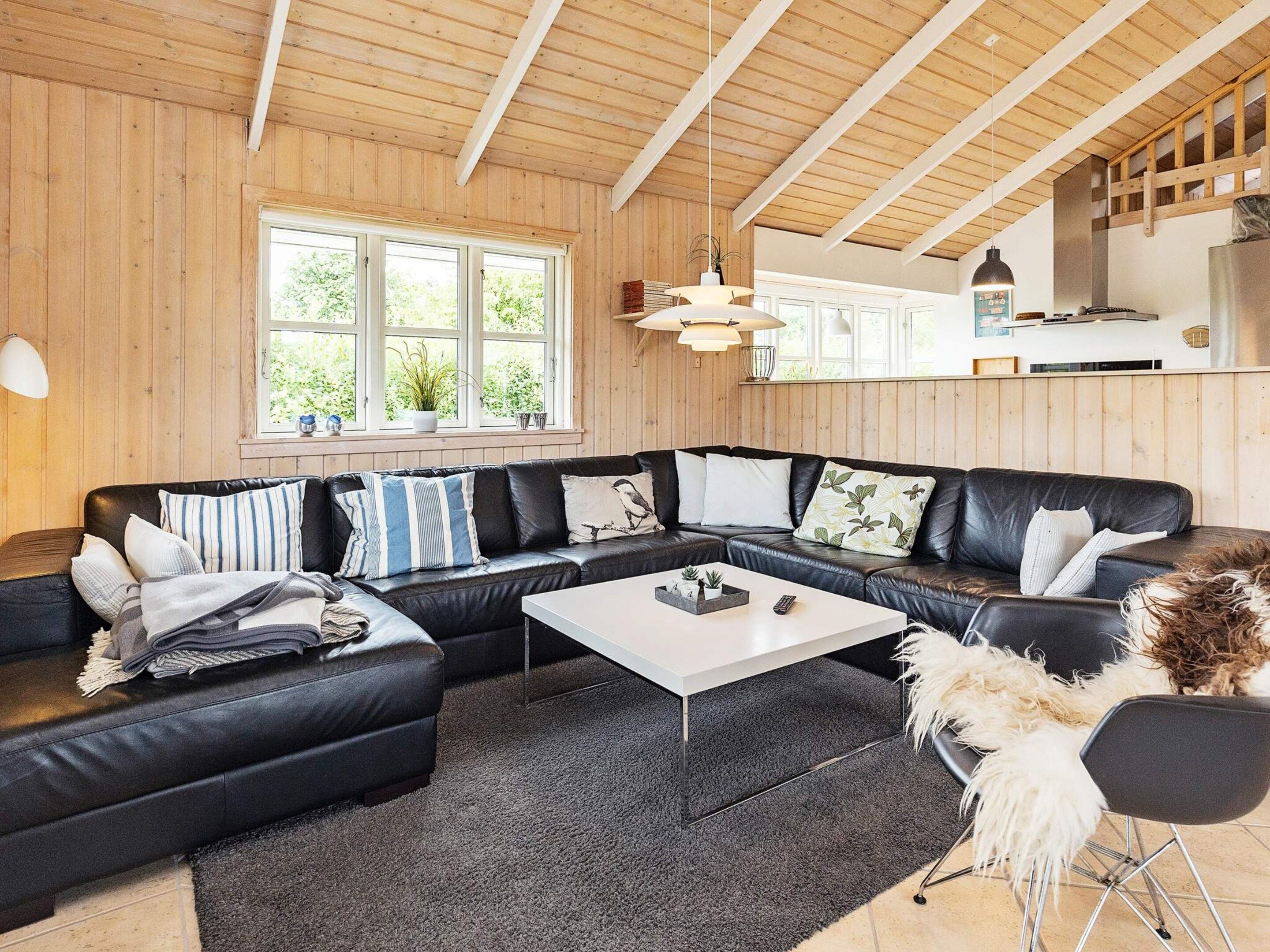 Een moderne woonkamer met een hoekbank, een salontafel en uitzicht op de keuken.