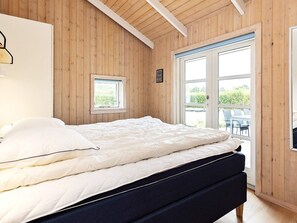 A bedroom with a bed, a window, and a door leading to an outdoor area. - 5 Star Holiday Home in Otterup (Otterup)